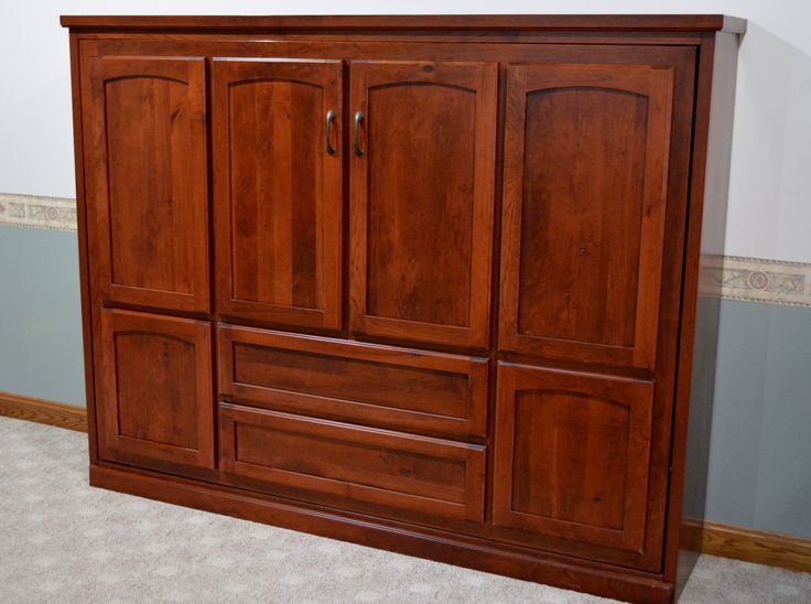 a large wooden cabinet in the corner of a room with carpeted floor and walls