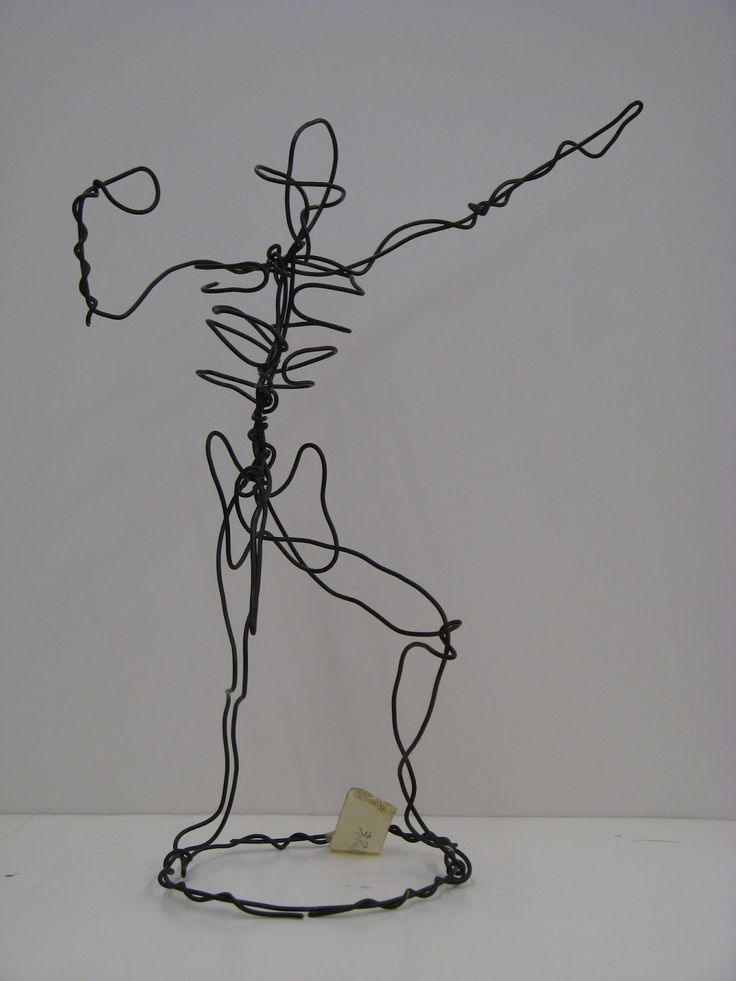 a wire sculpture holding a piece of paper