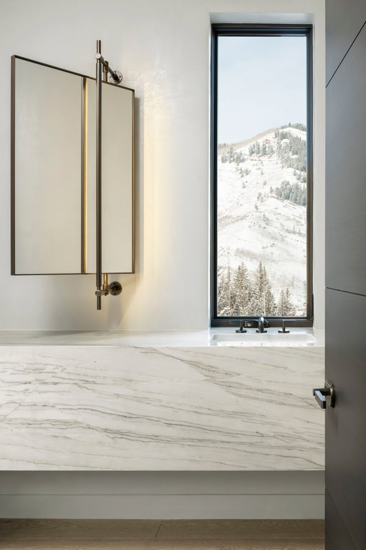 a bathroom with a large window and marble counter top