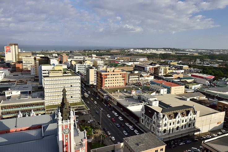 an aerial view of a city with tall buildings and cars driving down the street in front of them