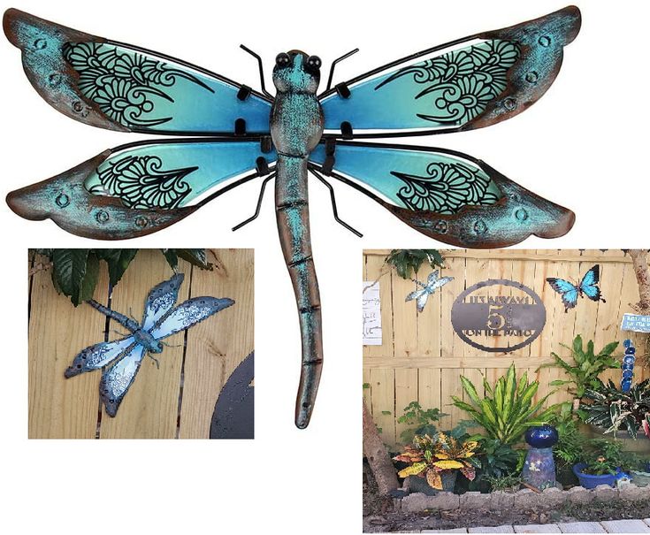 a blue dragonfly sitting on top of a wooden fence next to potted plants