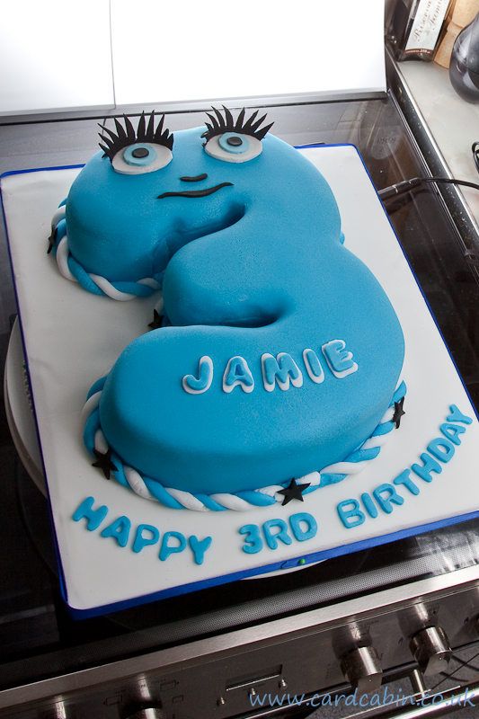 a blue birthday cake sitting on top of a stove