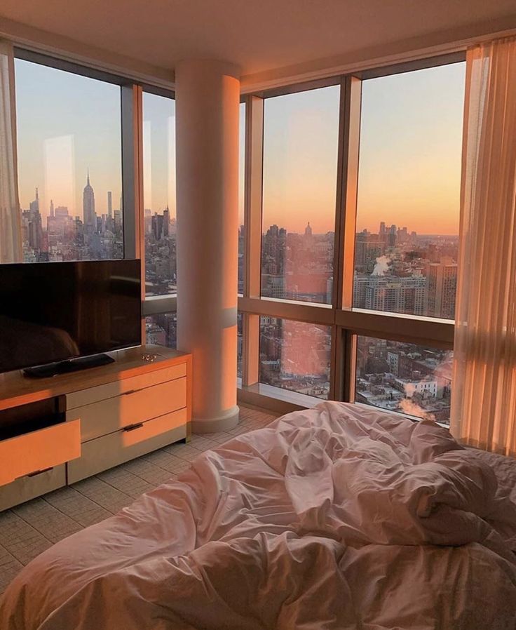 a bedroom with a large window overlooking the city