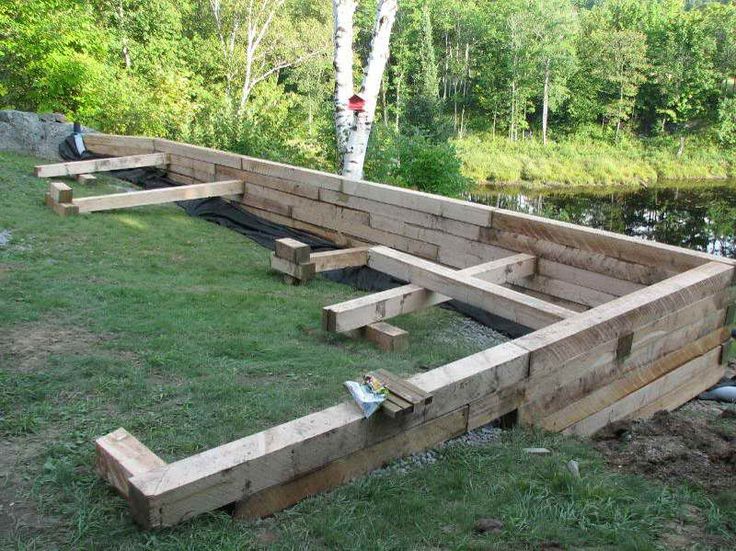 a wooden garden bed sitting on top of a lush green field