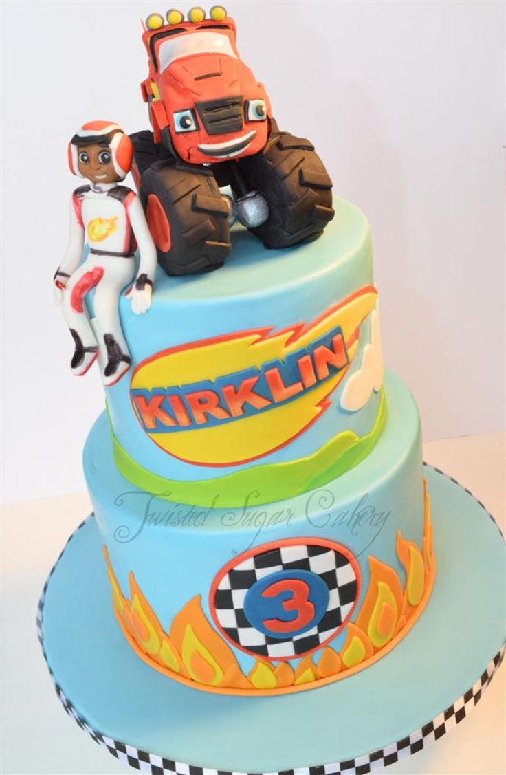 a three tiered cake decorated with cartoon characters on the front and sides, including an orange truck