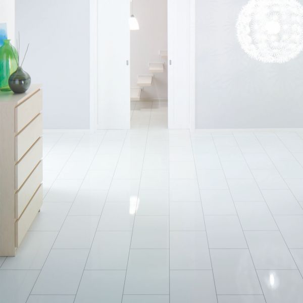 an empty room with white tile floors and green vases on the dresser next to it