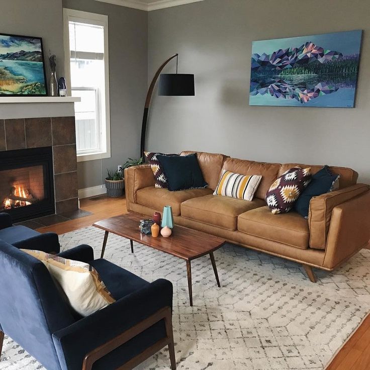 a living room with two couches and a fire place in the corner on top of a rug