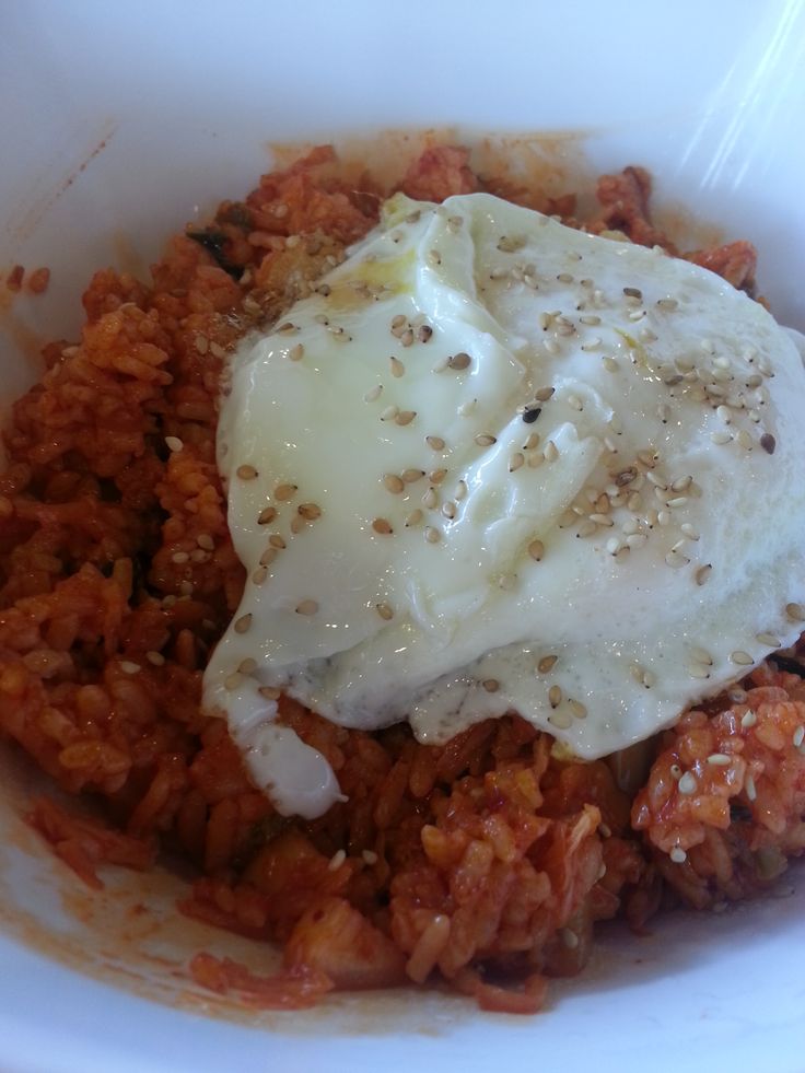 a white bowl filled with rice and meat covered in grated parmesan cheese