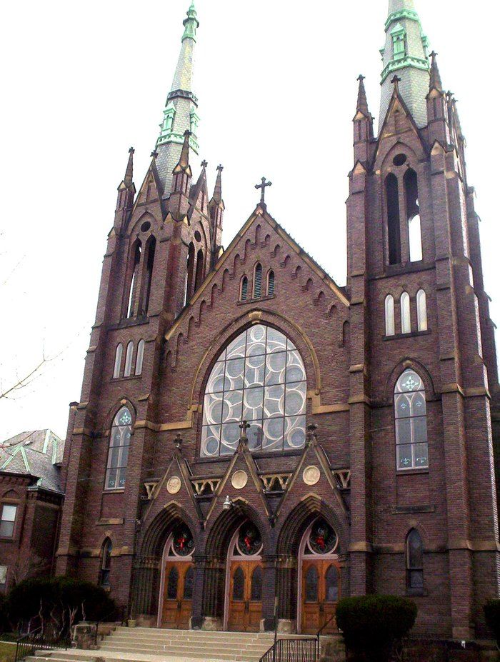 an old church with stained glass windows and steeples on the front door is shown