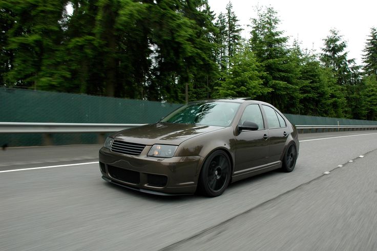 a car driving down the road with trees in the background