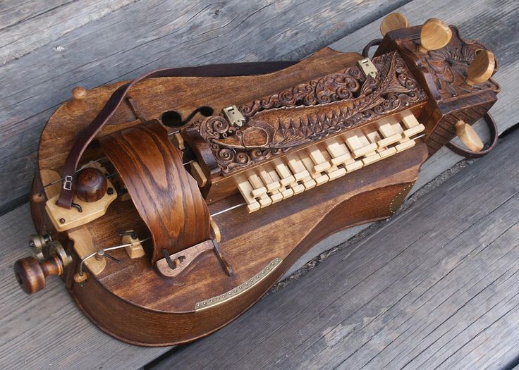 an old musical instrument is sitting on a bench with wood and metal parts around it