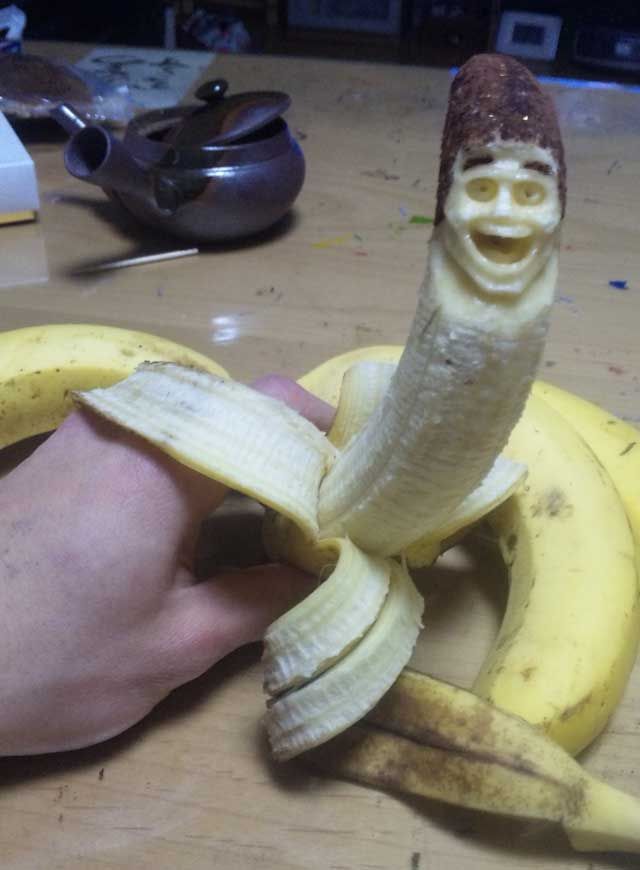 a person holding a banana with a face on it