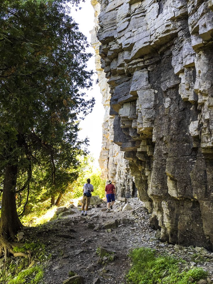 two people are hiking up a rocky trail