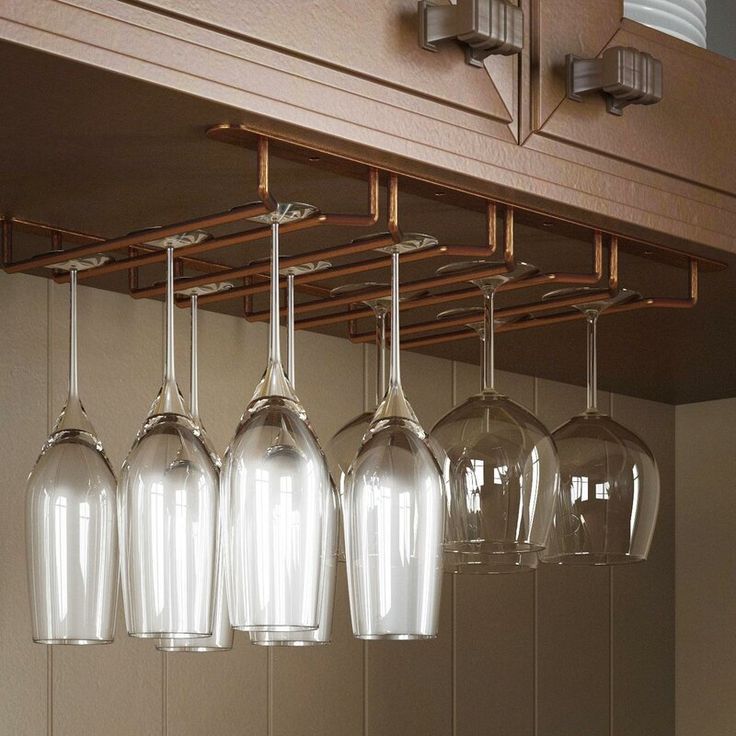 several wine glasses hanging from the ceiling in a kitchen