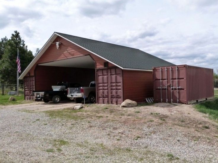 a truck is parked in front of a red barn with its doors open and the roof opened