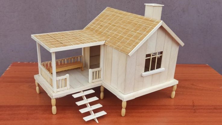 a doll house with stairs leading up to the roof and windows, on top of a wooden table