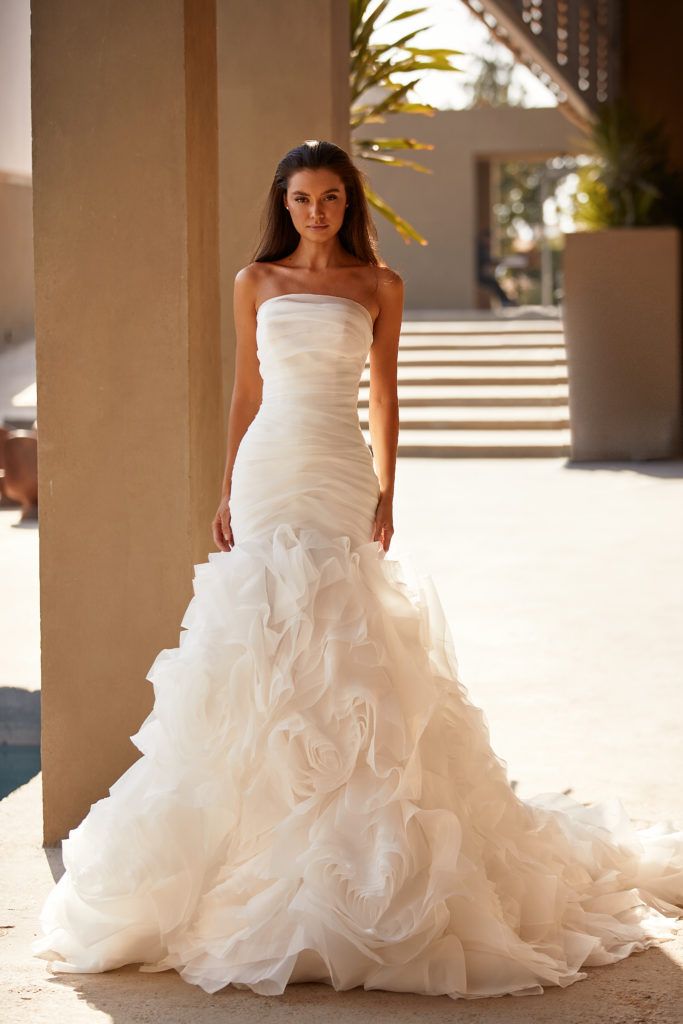 a woman in a white wedding dress posing for the camera