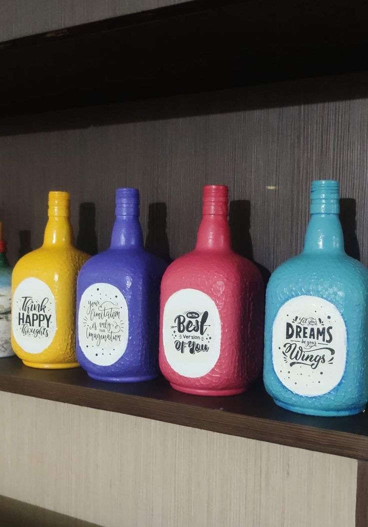 six different colored bottles sitting on top of a shelf