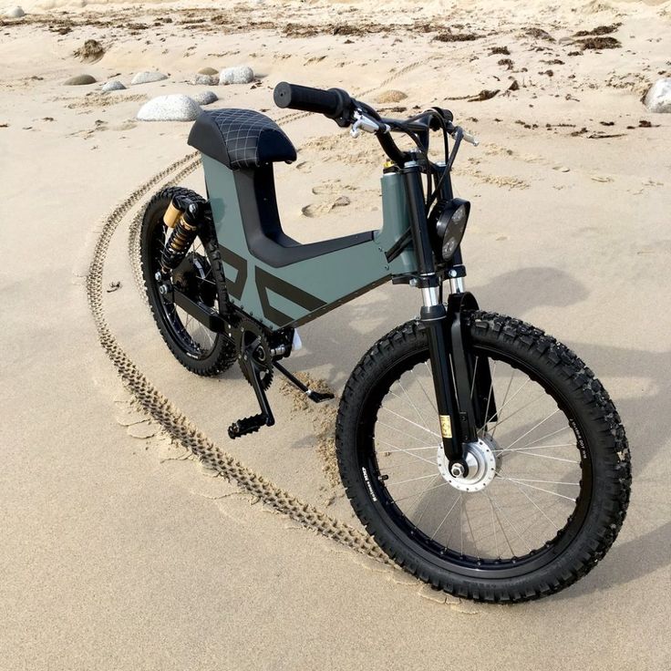 an electric bike parked on the beach with chains around it's tire rims