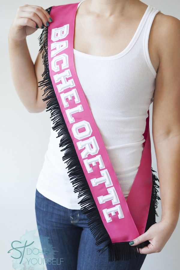 a woman holding a pink and black brush in her right hand while wearing a white tank top