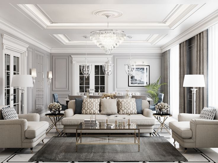 a living room filled with furniture and a chandelier hanging above the couches