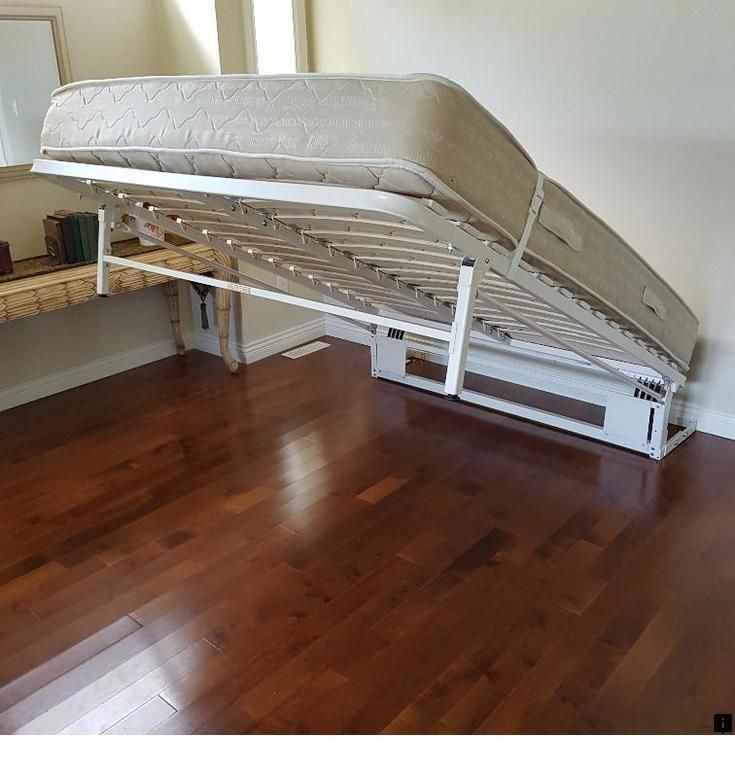 a white bed frame sitting on top of a hard wood floor