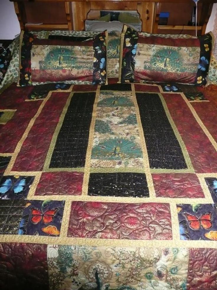 a bed covered in colorful quilts and pillows