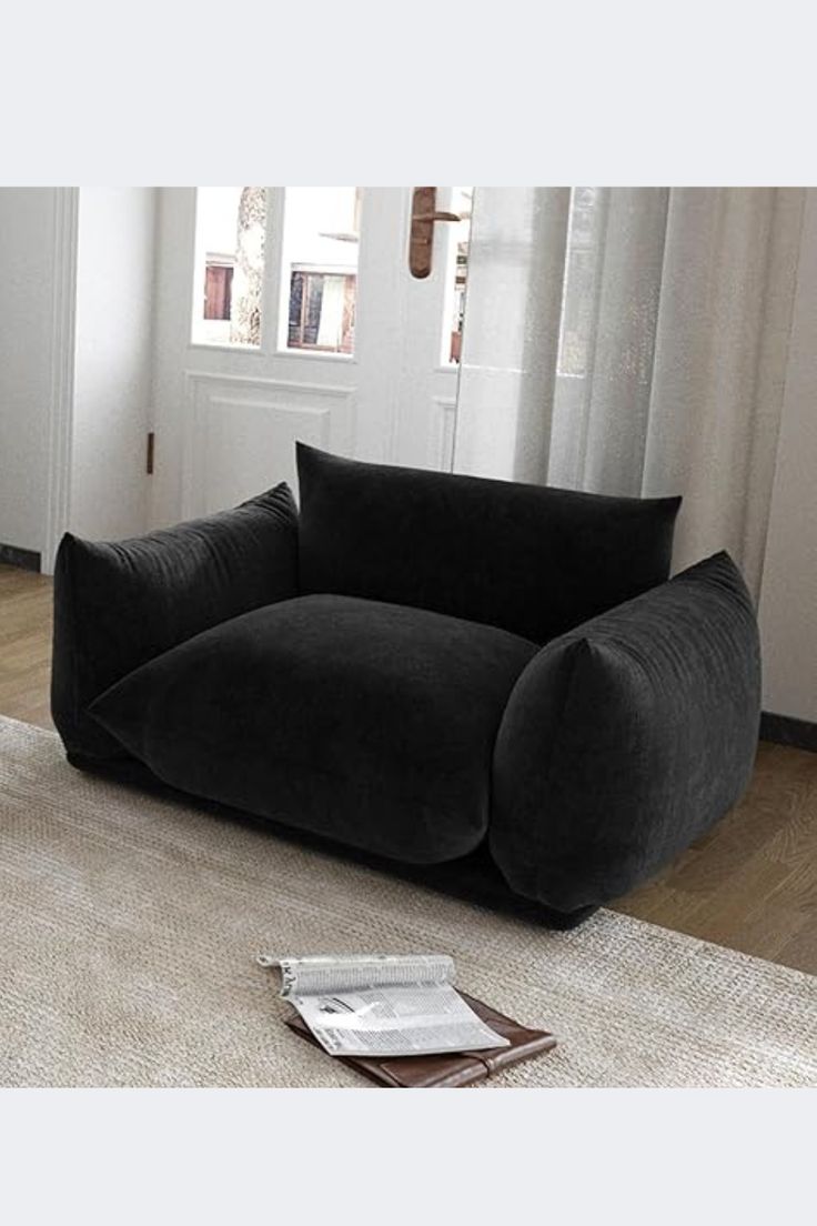 a black couch sitting on top of a white rug