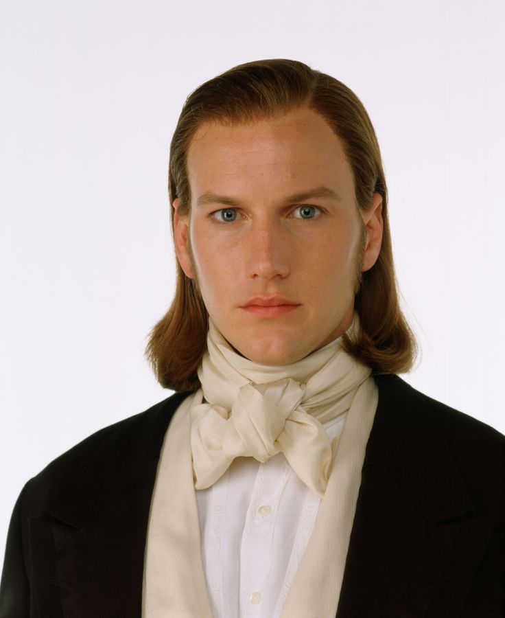 a young man in a tuxedo and bow tie looks at the camera while wearing a black jacket