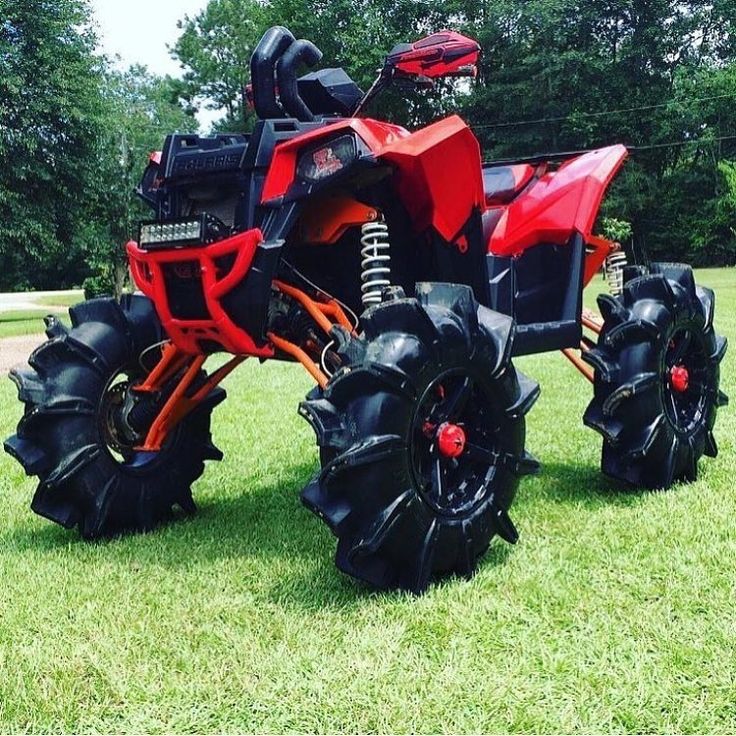 an orange and black four - wheeled vehicle parked in the grass