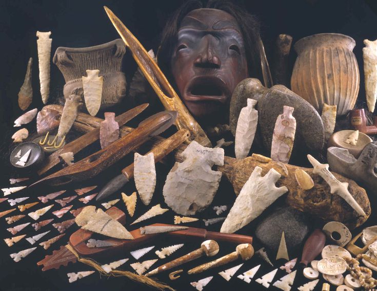 an assortment of tools and artifacts displayed in front of a woman's face with her mouth open