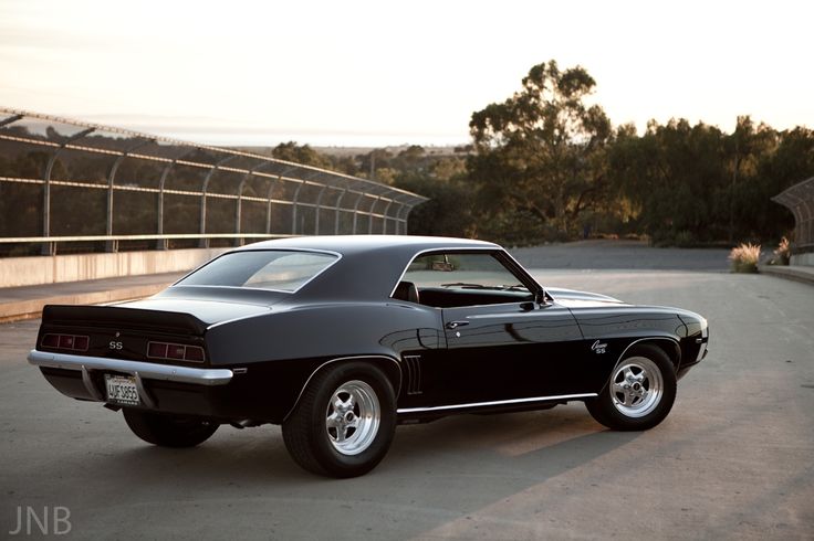 a black muscle car parked on the street