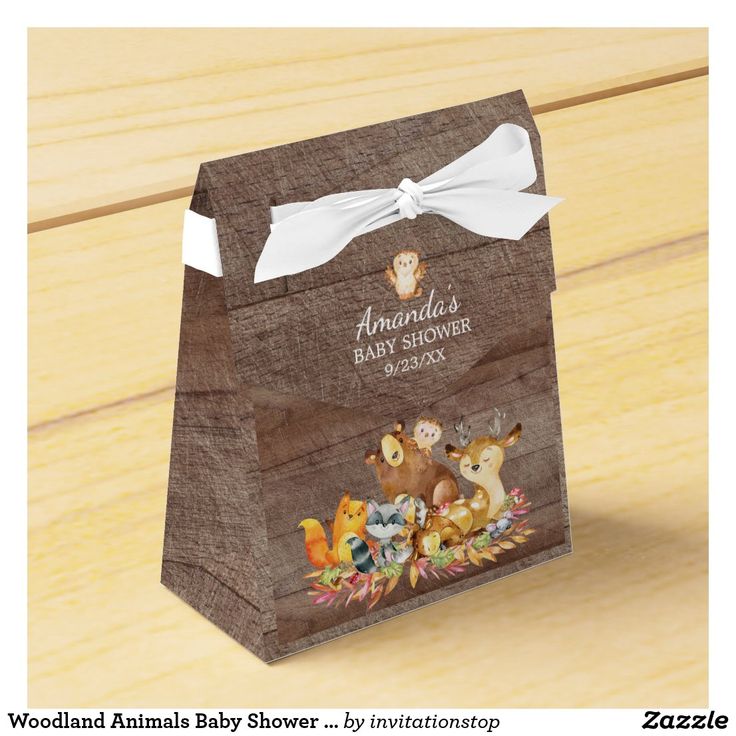 an animal themed baby shower gift bag on a wooden floor with the name woodland animals printed on it