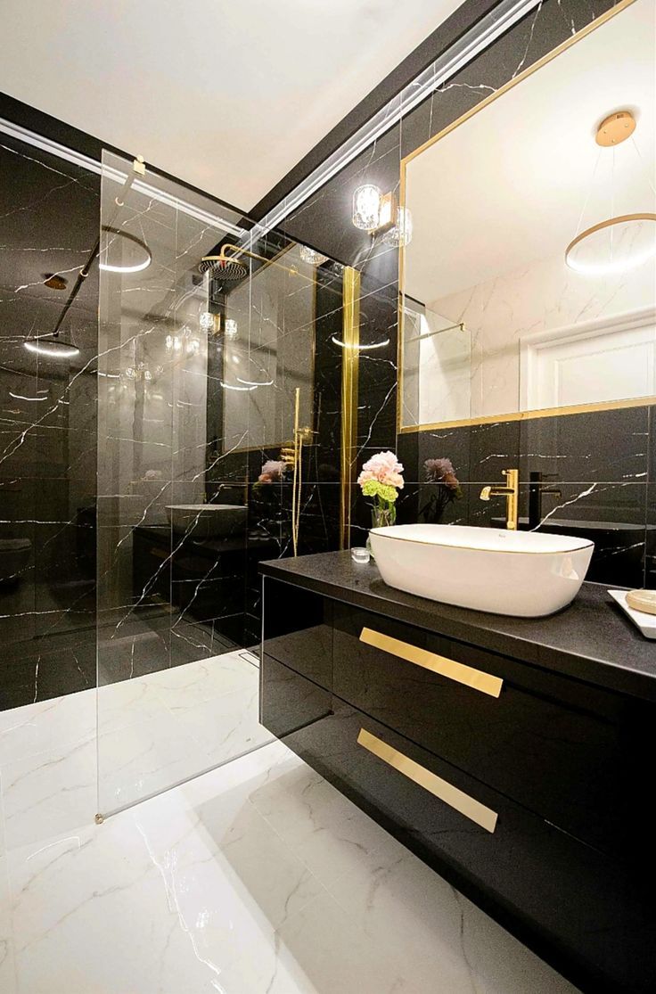 a black and white bathroom with gold accents