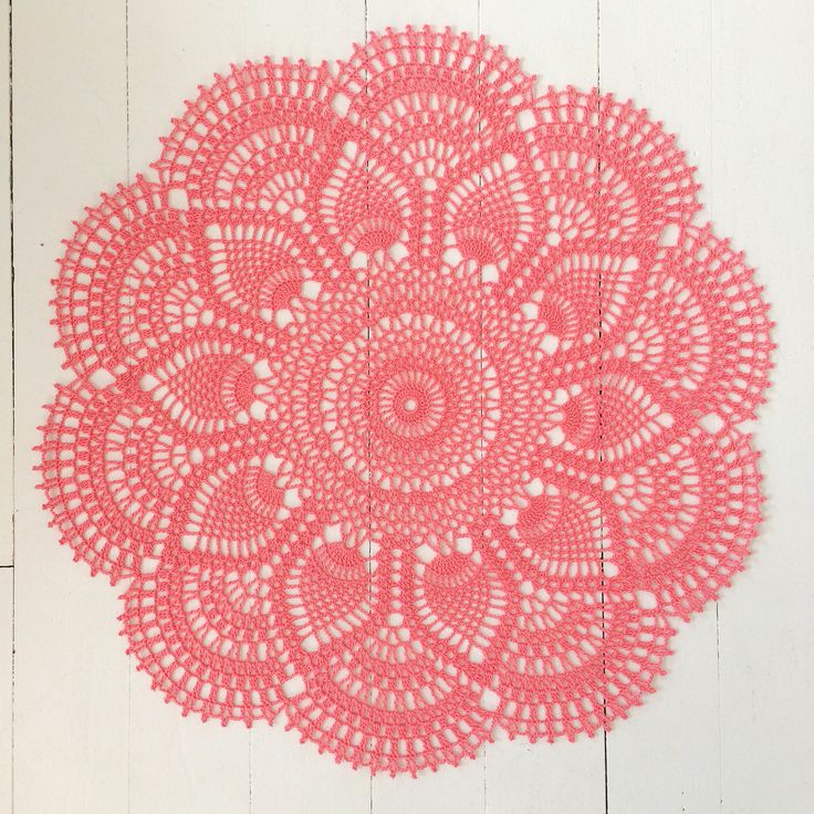 a pink doily is hanging on the wall