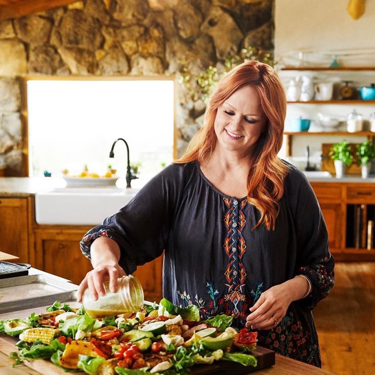 a woman is preparing a salad in the kitchen