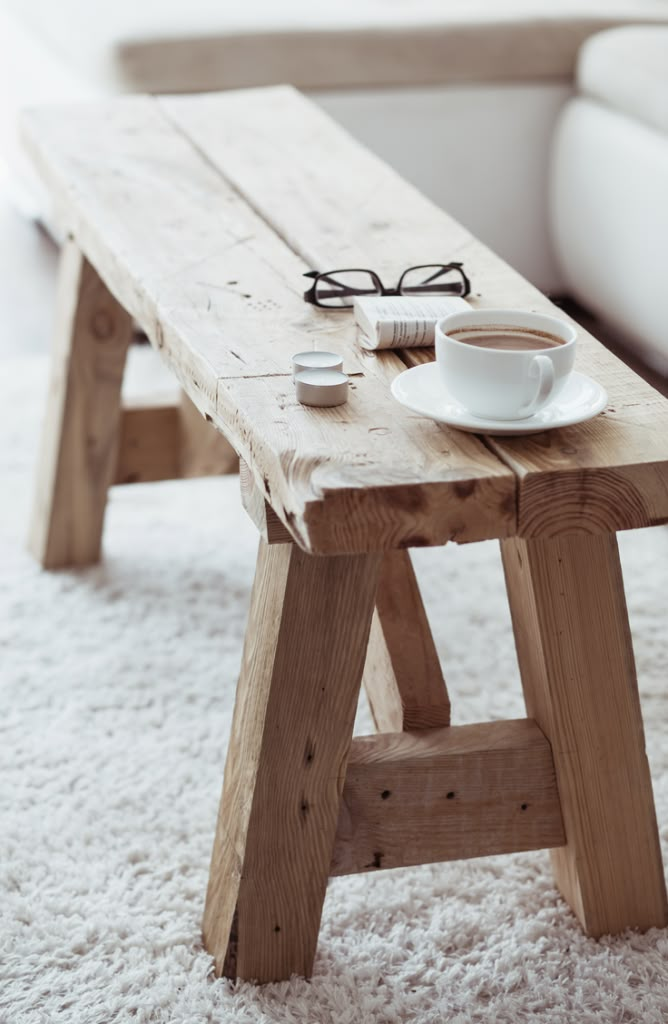 a coffee table with a magazine and cup on it