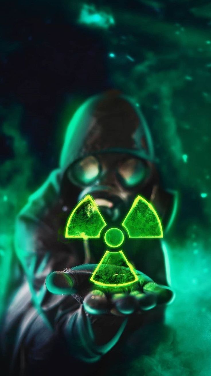 a man in a gas mask holding up a radioactive symbol