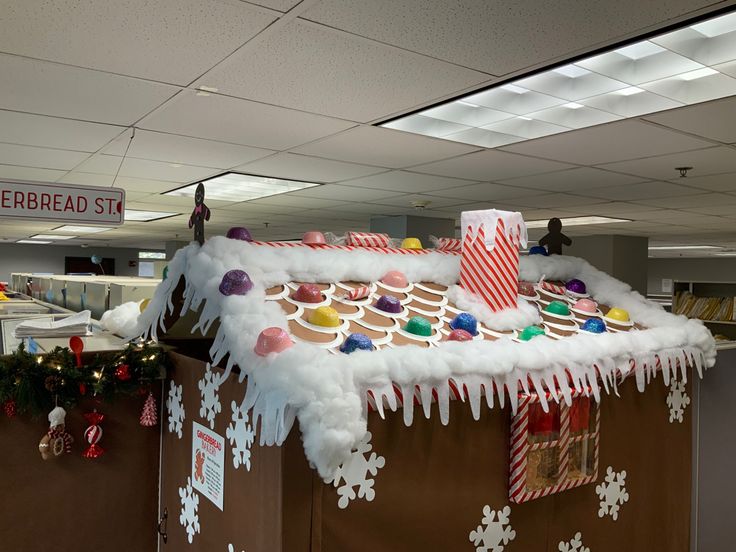 an office cubicle decorated for christmas with gingerbread house