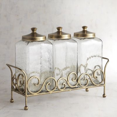 three glass jars with metal handles on a stand