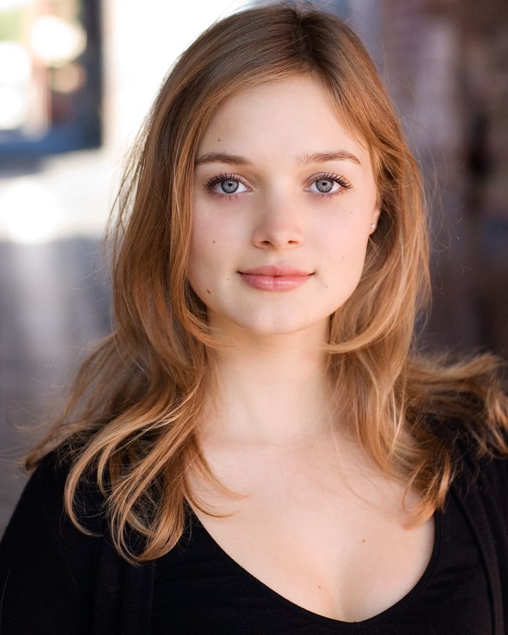 a beautiful young woman with blue eyes posing for a photo