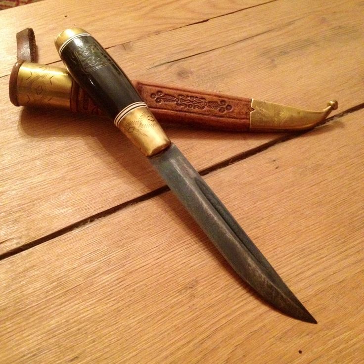 two knives are sitting on the table next to each other, one is gold and the other is black