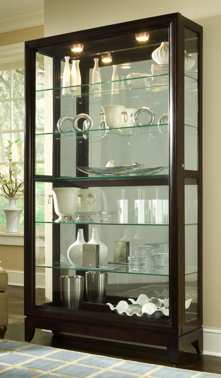 a glass display case filled with dishes and cups