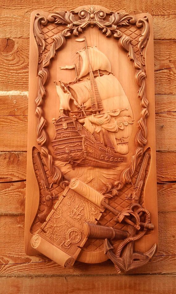 a carved wooden plaque with a ship and other items on it's side, in front of a wood paneled wall