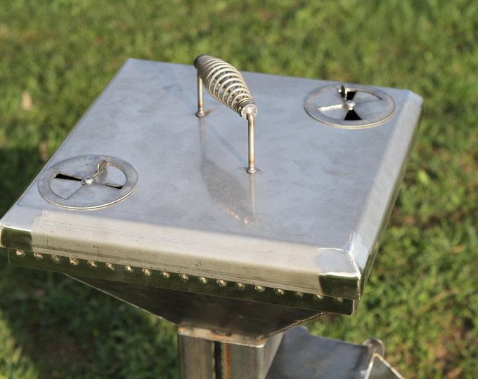 a metal object with two springs attached to it's sides on the ground in front of some grass