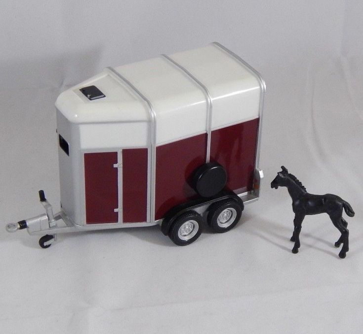 a toy horse and trailer on a white background