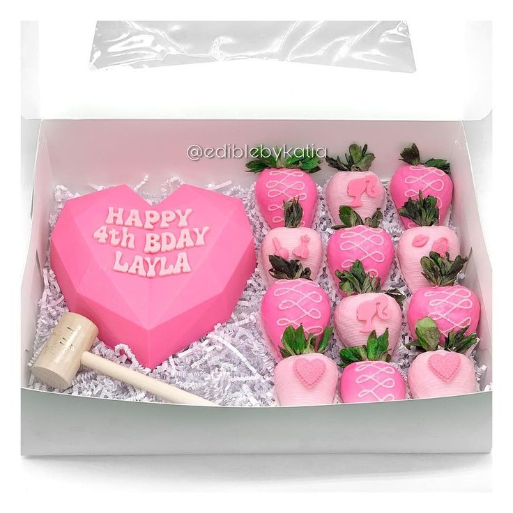 a pink box filled with lots of fake strawberries