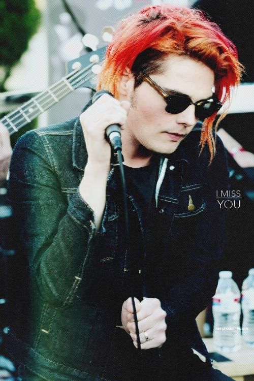 a man with red hair and sunglasses holding a guitar