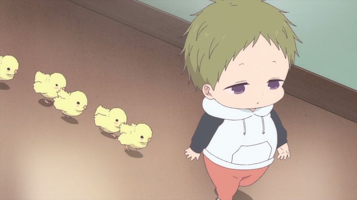 a young boy standing in front of some little yellow rubber ducklings on the floor