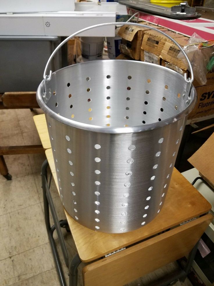 a metal bucket sitting on top of a wooden table